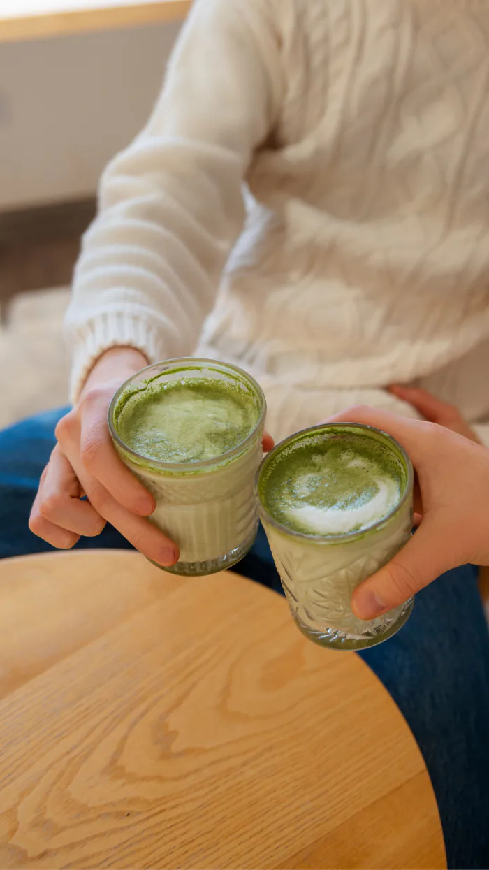 Persona sosteniendo dos vasos de matcha