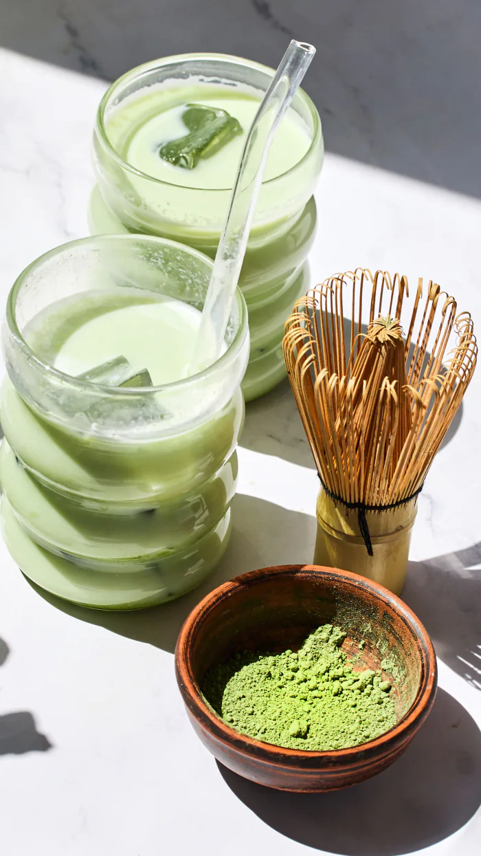 Dos vasos de matcha frío y un batidor