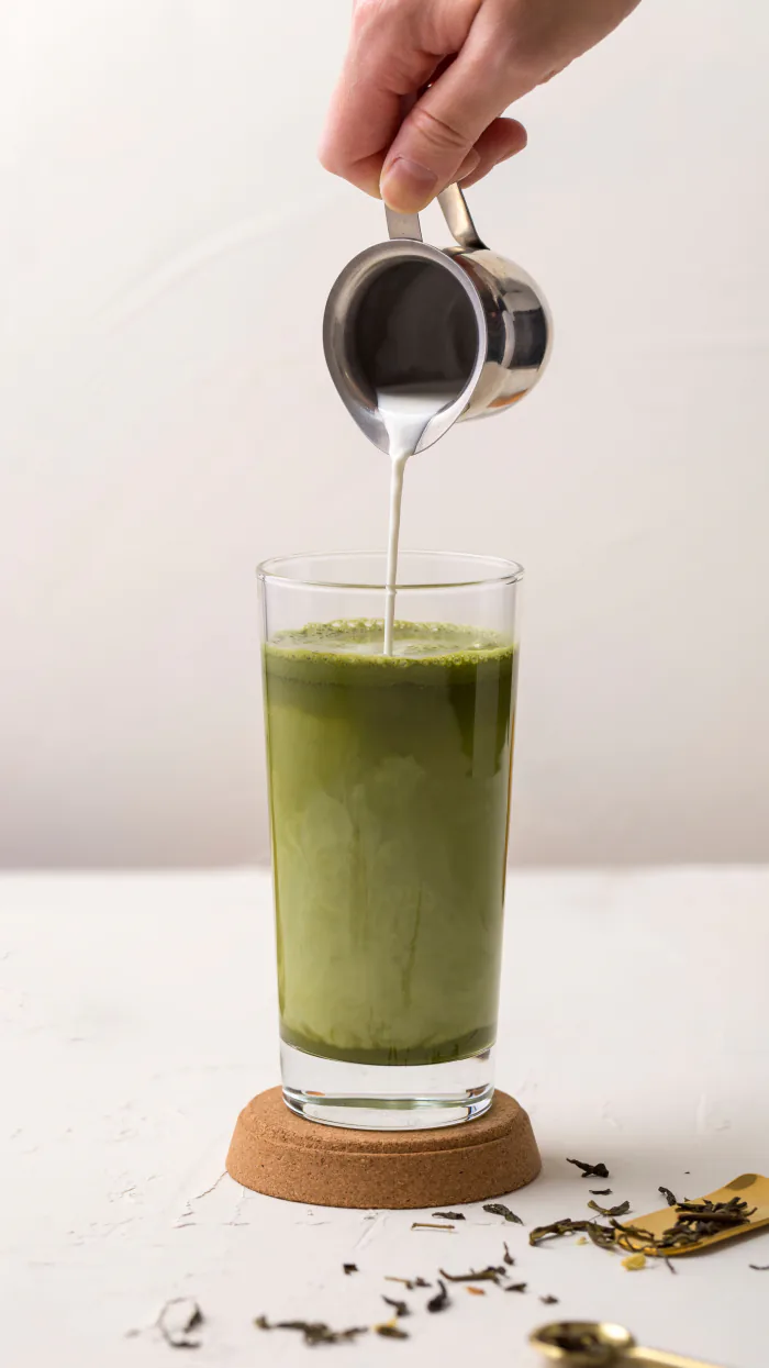 Leche vertiéndose sobre un matcha frío